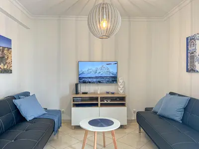 a living room with two blue couches and a tv at Old Town 2BR 50m Ocean w/ AC Wi-Fi Parking Terrace in Albufeira