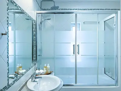 a bathroom with a glass shower and a sink at Old Town 2BR 50m Ocean w/ AC Wi-Fi Parking Terrace in Albufeira