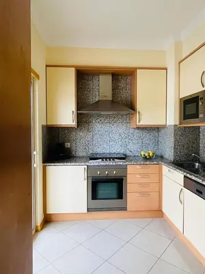 a kitchen with white cabinets and a stove top oven at by blen.d in Albufeira