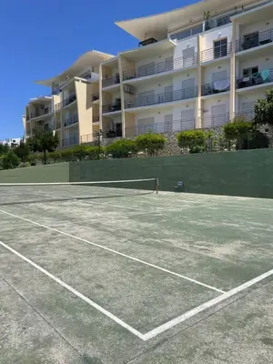 a tennis court in front of a large building at by blen.d in Albufeira