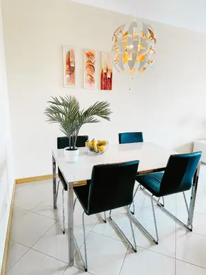 a dining room table with chairs and a chandelier at by blen.d in Albufeira