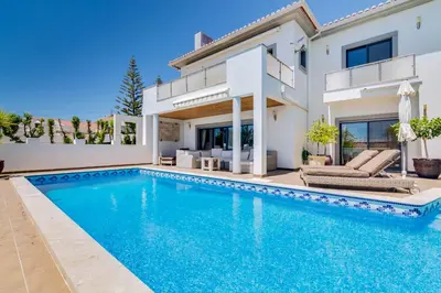 a villa with a swimming pool and a house at Ocean View Villa in Boliqueime