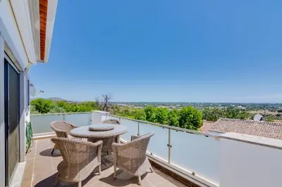 a patio with a table and chairs on a balcony at Ocean View Villa in Boliqueime