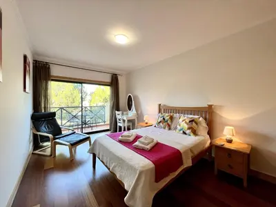a bedroom with a large bed and a balcony at Albufeira Modern 4 With Pool by Homing in Albufeira