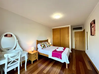 a bedroom with a bed and a vanity and a mirror at Albufeira Modern 4 With Pool by Homing in Albufeira