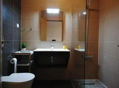 a bathroom with a sink and a toilet and a shower at Spacieux Appartement Logis des Fées de la Marina en rez-de-chaussée de chaussée in Albufeira