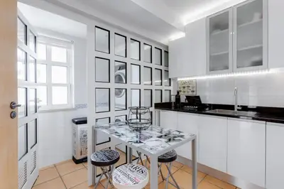 a white kitchen with a table and two stools at VILASOL - 