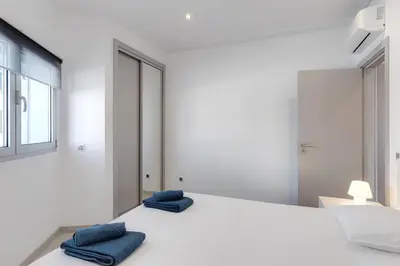 a white bedroom with a bed with blue towels on it at VILLA LIMOEIRO - Beautiful new home nestled in the heart of Galé in Guia