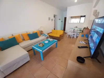 a living room with a couch and a flat screen tv at Apartamento Joyce by Sunnyway in Albufeira