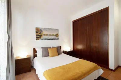a bedroom with a large bed with a wooden headboard at Apartamento Joyce by Sunnyway in Albufeira