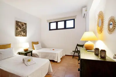 a room with two beds and a table with a lamp at Apartamento Joyce by Sunnyway in Albufeira