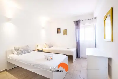 a small white room with a bed and a table at #112 Oura Flat by Home Holidays in Albufeira