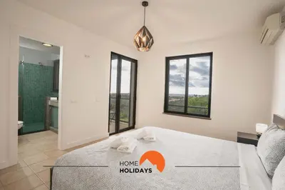 a bedroom with a bed and a bathroom with windows at #111 Ocean View by Home Holidays in Albufeira