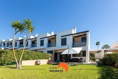 a large white building with a palm tree in front of it at #111 Ocean View by Home Holidays in Albufeira
