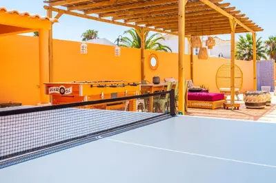 a tennis court with a net in front of a house at Villa Habitate - pool fence & heating beach bars in Albufeira