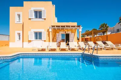 a swimming pool with chairs and a house at Villa Habitate - pool fence & heating beach bars in Albufeira