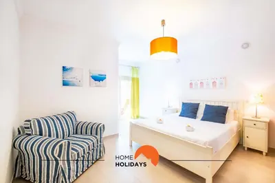 a bedroom with a bed and a chair at #115 Bernardo Flat by Home Holidays in Albufeira