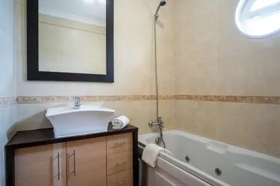 a bathroom with a sink and a tub and a mirror at Apartment Hugo - Complex perfect for families in Albufeira