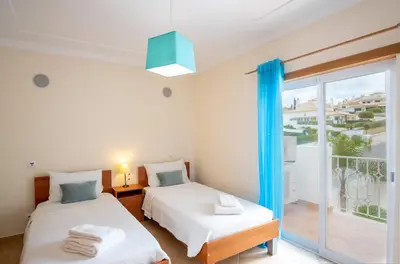 a bedroom with two beds and a balcony at Apartment Hugo - Complex perfect for families in Albufeira