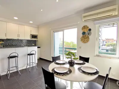 a kitchen and dining room with a table and chairs at Vilamoura Neptuno in Quarteira