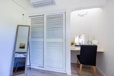 a room with a closet with a mirror and a desk at Muito Sol in Albufeira