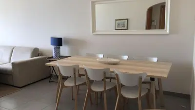 a dining room table with white chairs and a mirror at Pure Sea - Beach Apartment in Quarteira