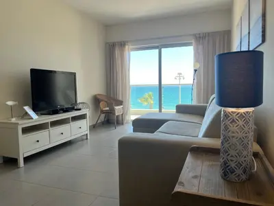 a living room with a couch and a flat screen tv at Pure Sea - Beach Apartment in Quarteira