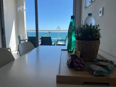 a table with a potted plant and a bottle on it at Pure Sea - Beach Apartment in Quarteira