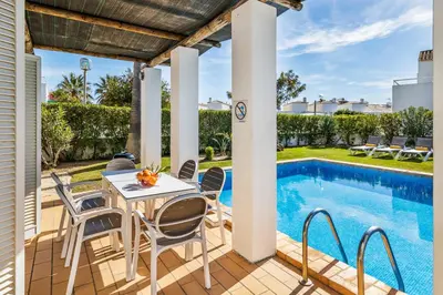 a patio with a table and chairs next to a swimming pool at Villa Luz do Atlantico by OCvillas in Galé