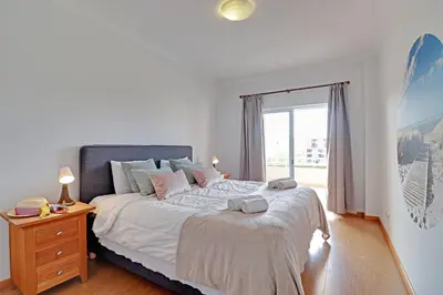 a bedroom with a large bed and a window at Palm Beach Apartment in Vilamoura