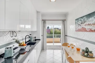 a room with a table and a mirror on a wall at Palm Beach Apartment in Vilamoura