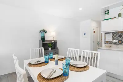 a white dining room with a white table and chairs at Apartamento Acácia in Vale do Lobo