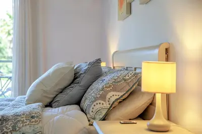 a living room with a couch with pillows and a lamp at Luxury Apartment with Pool in Albufeira
