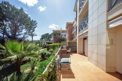 a balcony of a building with chairs and trees at Luxury Apartment with Pool in Albufeira