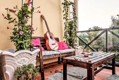 a guitar sitting on a bench on a porch at Luxury Apartment with Pool in Albufeira