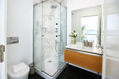 a bathroom with a shower and a toilet and a sink at Under the moon in Faro