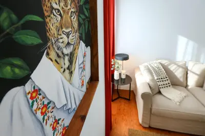 a living room with a couch and a painting of a leopard at Under the moon in Faro