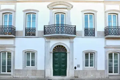 a facade of a white building with a green door at Under the moon in Faro