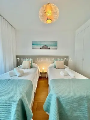 two beds in a room with a chandelier at Prime Lux Albufeira in Albufeira