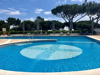 a large swimming pool with blue water at Beautiful apartment set in the heart of Quinta - Newly Refurbished in Almancil