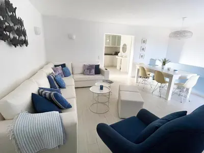 a living room with a white couch and blue chairs at Beautiful apartment set in the heart of Quinta - Newly Refurbished in Almancil