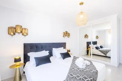 two beds in a white room with a bedroom at Apartment Maria - Complex with tennis court and restaurant,pool in Albufeira