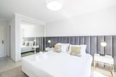 a white bedroom with a large bed and a mirror at Apartment Maria - Complex with tennis court and restaurant,pool in Albufeira