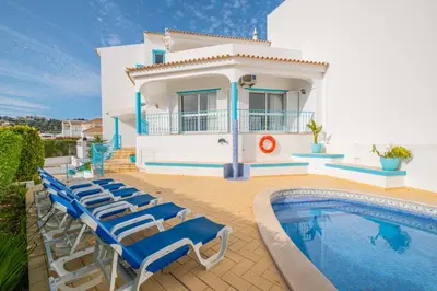 a villa with a swimming pool and a house at Villa Loria - beautiful panoramic views in Albufeira
