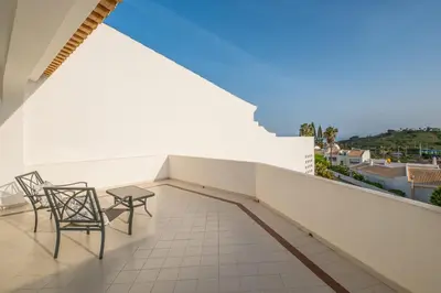 a balcony with two chairs and a table at Villa Loria - beautiful panoramic views in Albufeira