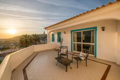 a balcony of a house with two chairs and a table at Villa Loria - beautiful panoramic views in Albufeira