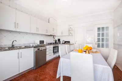 a kitchen with white cabinets and a table with oranges on it at Villa Loria - beautiful panoramic views in Albufeira