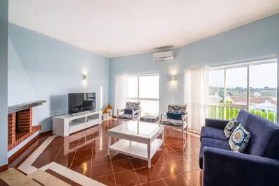 a living room with a couch and a tv at Villa Loria - beautiful panoramic views in Albufeira