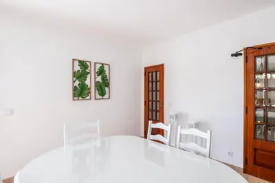 a dining room with a white table and chairs at Patroves Ranch - private pool & sea views in Albufeira