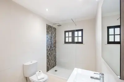 a white bathroom with a toilet and a shower at Patroves Ranch - private pool & sea views in Albufeira